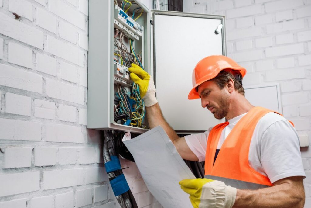 electrician looking at electrical distribution box