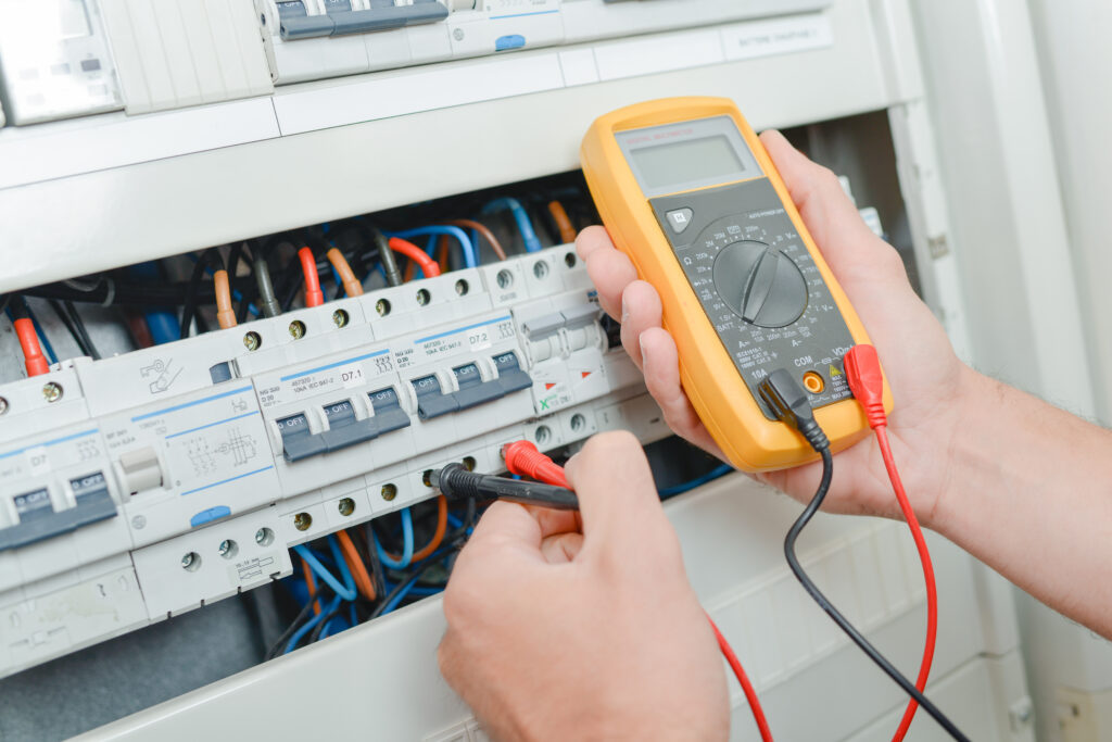 Electrician testing electrical current during fixed wire testing.