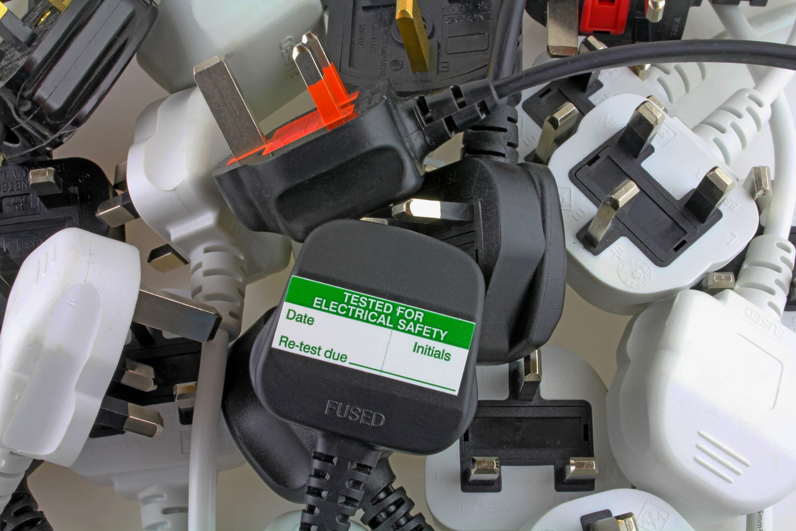 Blank Pat Testing Label on plug with several more plugs in a pile.